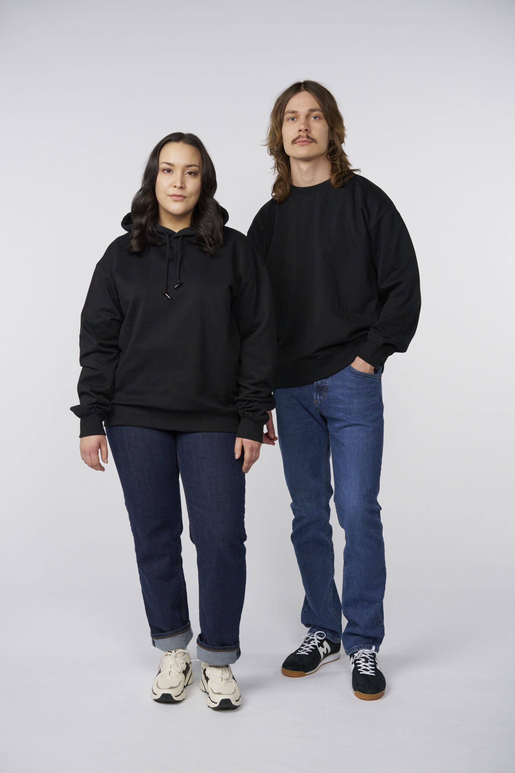 Woman in loose fit hoodie and man in loose fit sweathirt